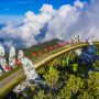 Aerial view of the Golden Bridge is lifted by two giant hands and two rows of Vietnamese flags on Ba Na Hill in Danang, Vietnam. Travel and landscape concept